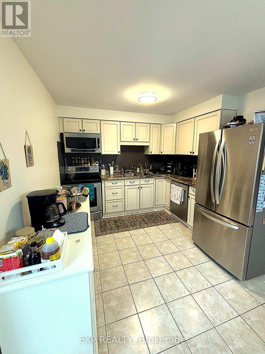 A kitchen with a refrigerator, microwave, and oven.