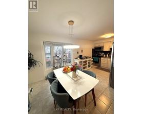 A dining room with a table set for two and a view of the backyard.