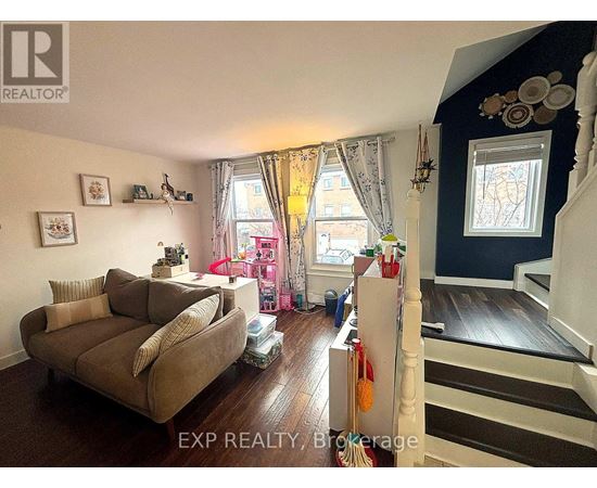 A living room with a couch and a staircase.