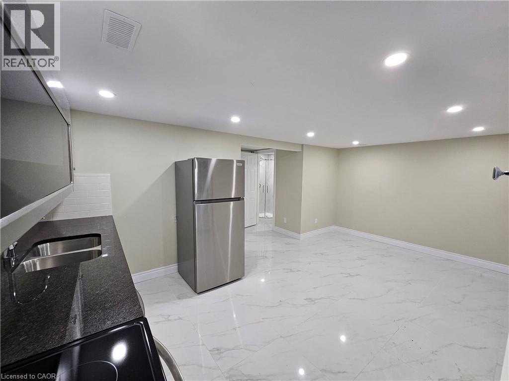 A kitchen with a sink, refrigerator, and countertop.