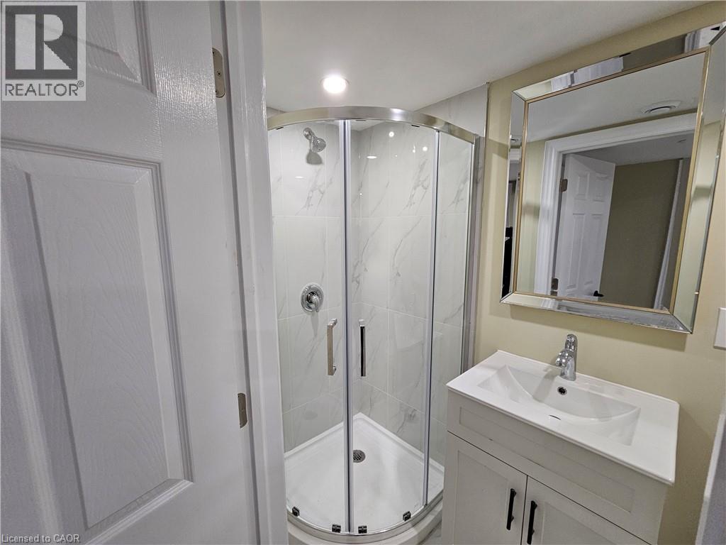 A bathroom with a sink, mirror, and shower.