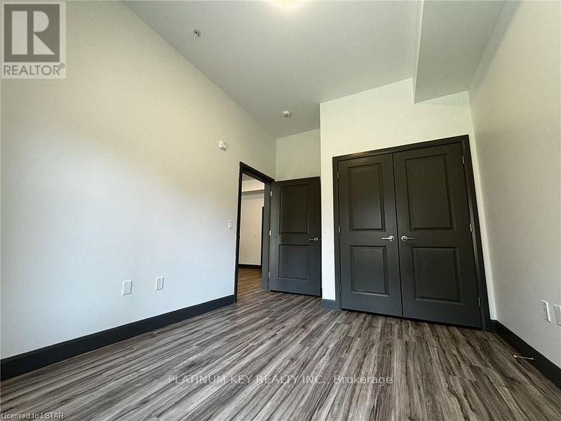 A room with a wood floor and a wall with switches.
