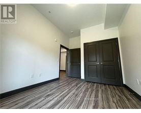 A room with a wood floor and a wall with switches.