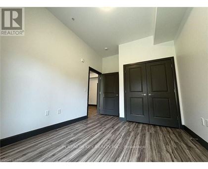 A room with a wood floor and a wall with switches.