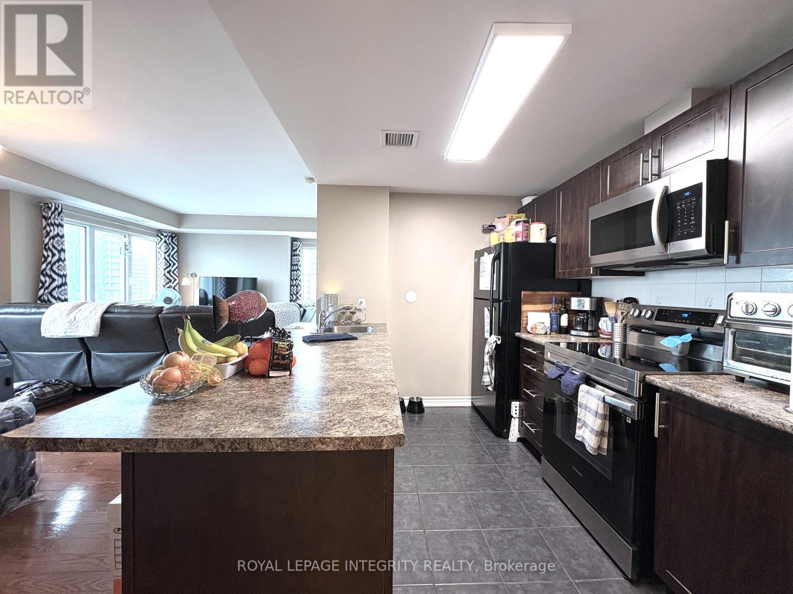 A kitchen with a granite countertop and a microwave above it.