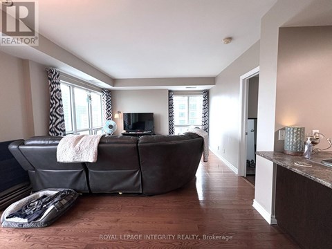 A living room with a brown leather couch and a flat screen TV.