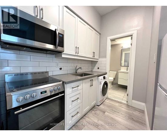A kitchen with white cabinets and a stainless steel oven.
