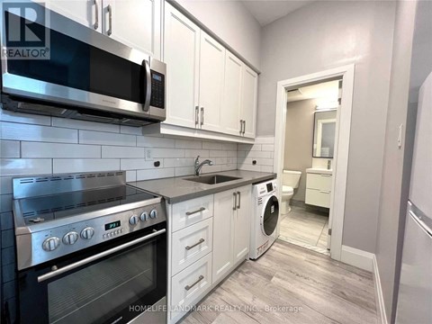 A kitchen with white cabinets and a stainless steel oven.