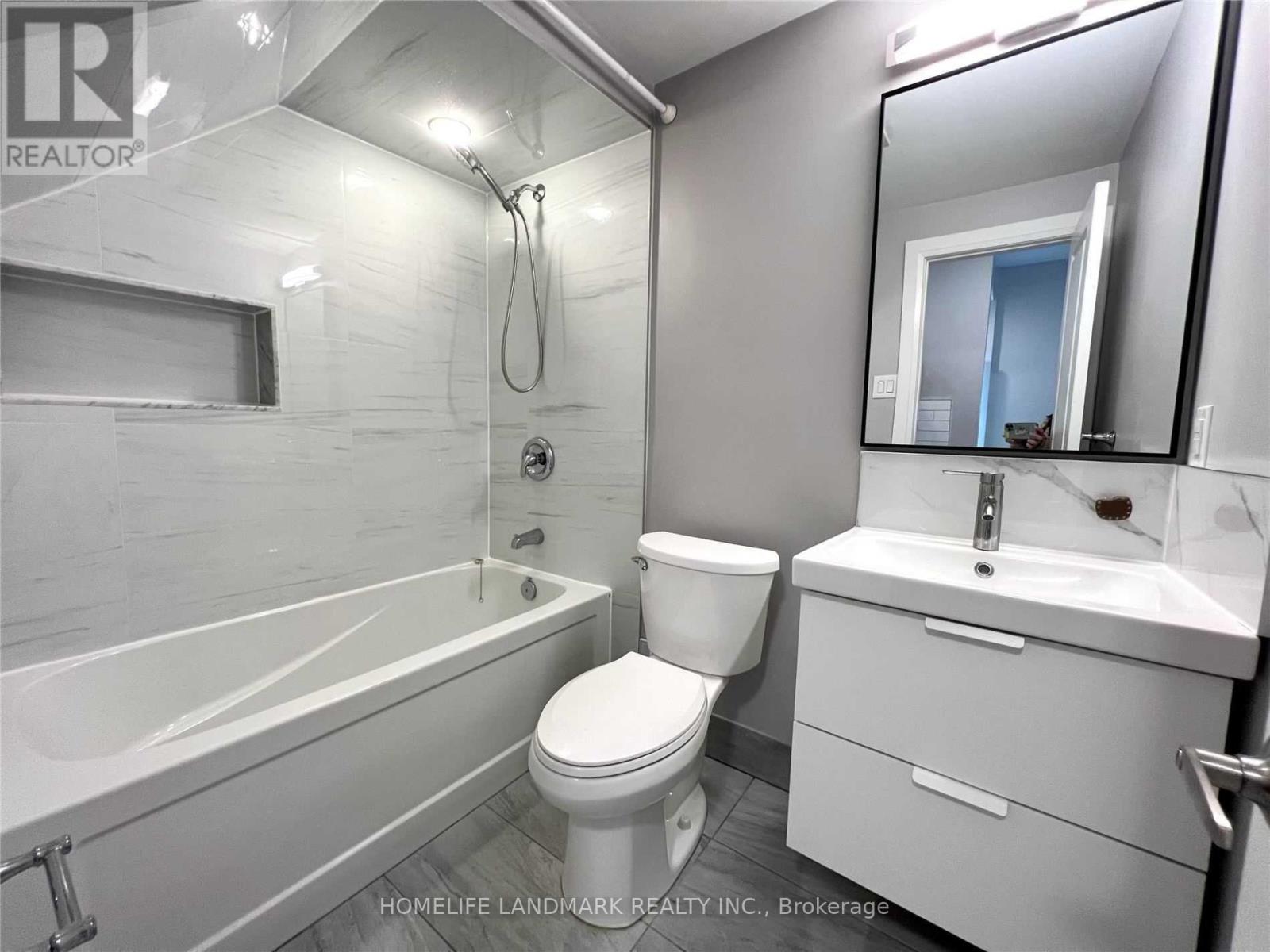 A white bathroom with a toilet, sink, and bathtub.