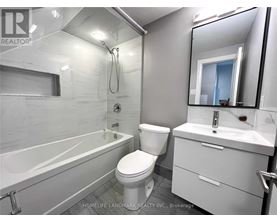 A white bathroom with a toilet, sink, and bathtub.
