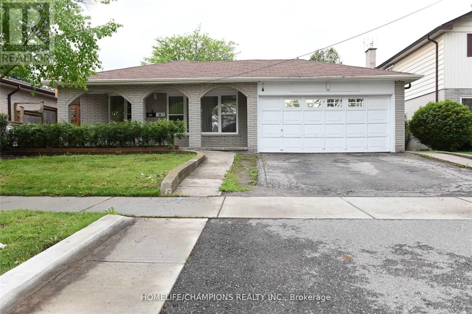A house with a garage and a driveway in front of it.