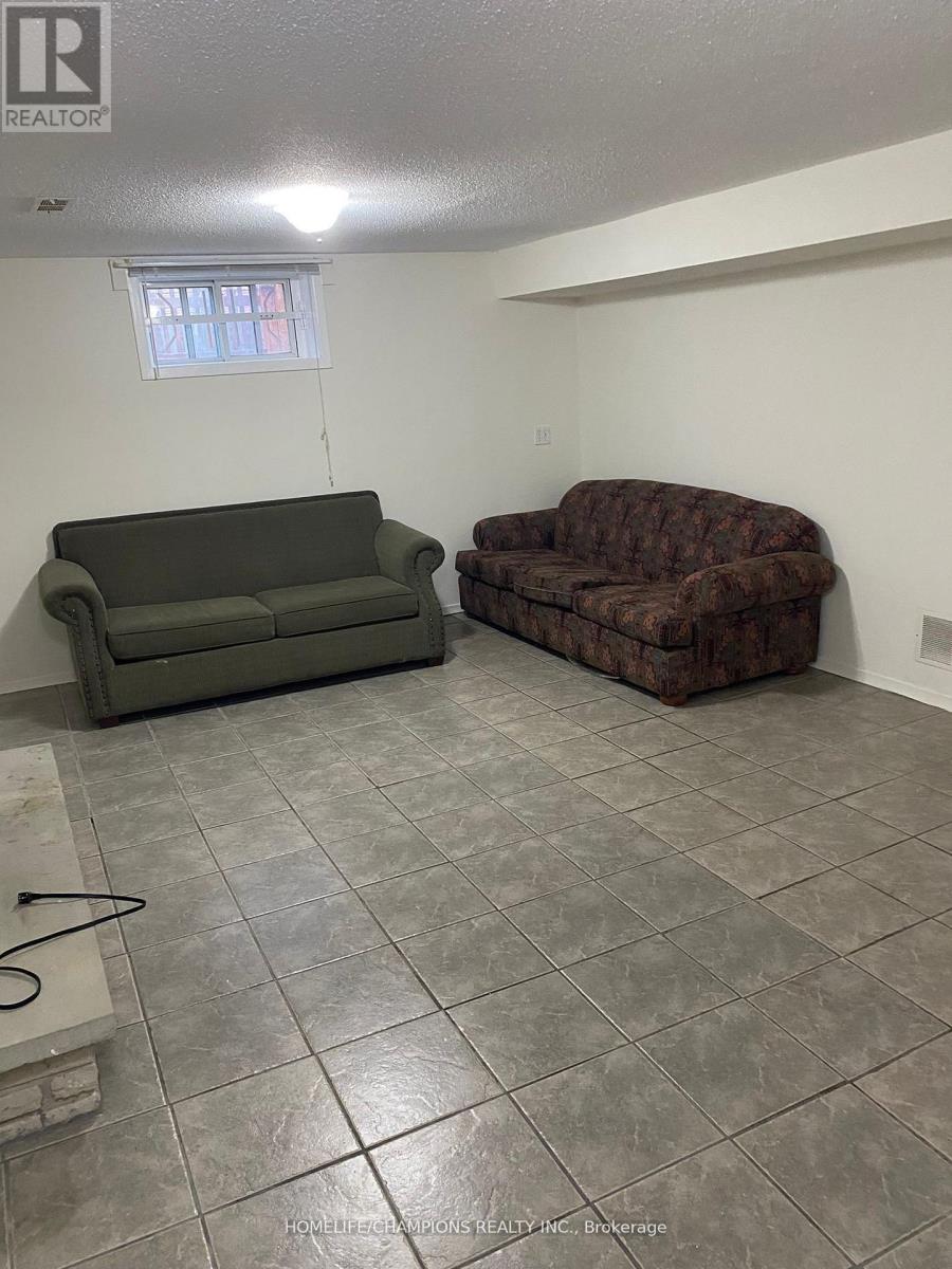 A living room with a grey couch and a brown recliner.