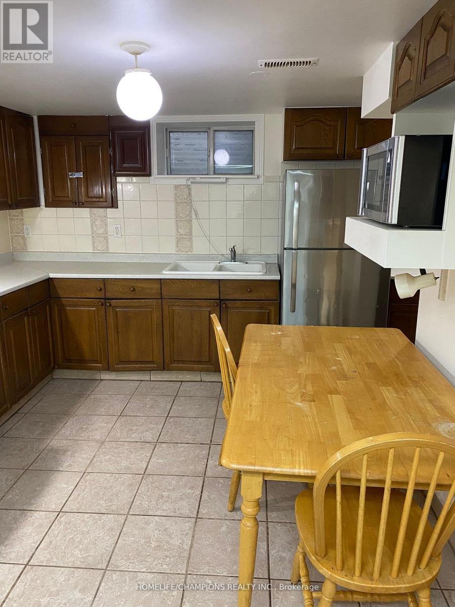 A kitchen with a wooden table and chairs.