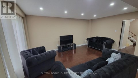 A living room with black furniture and a flat screen TV.