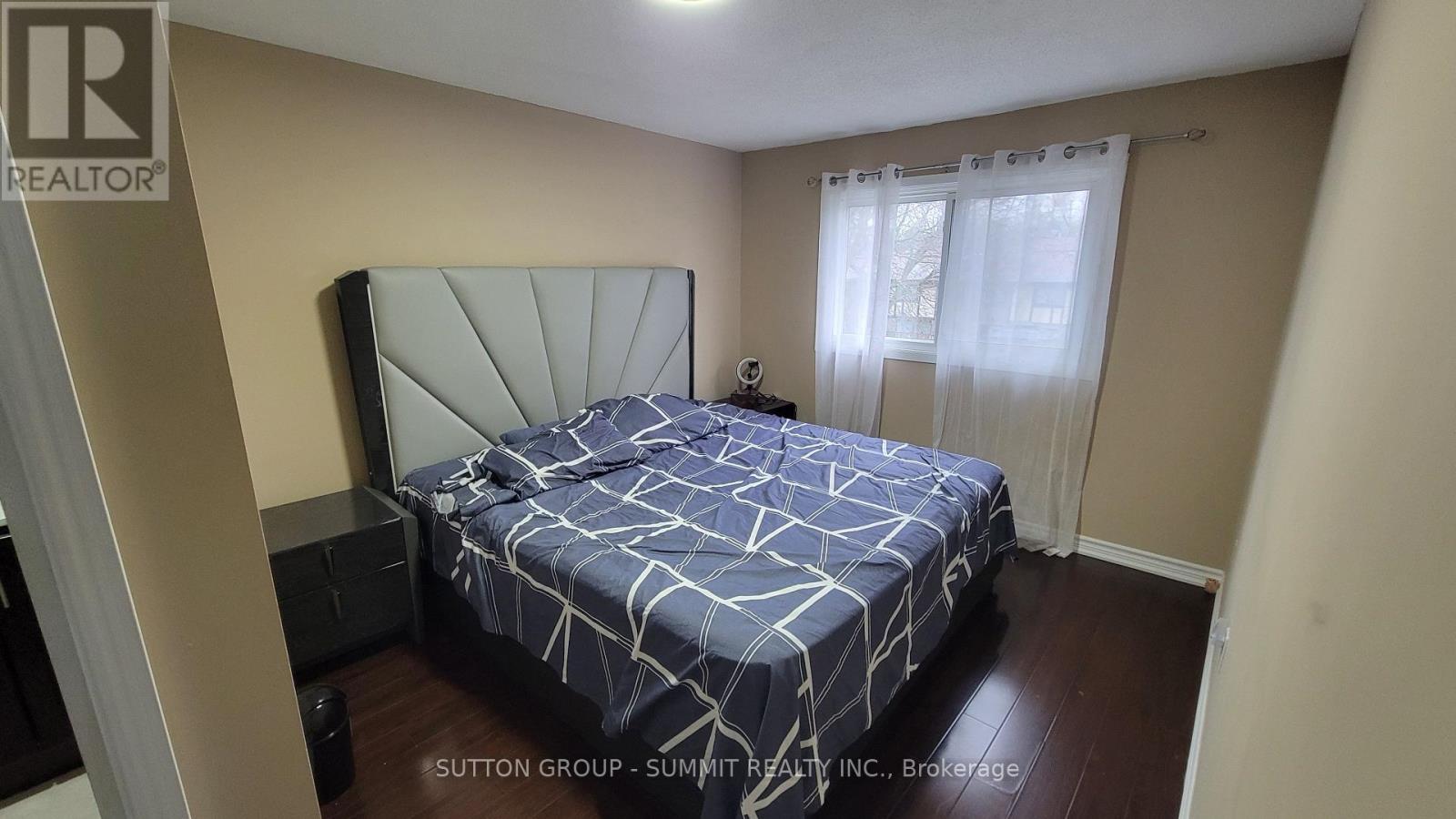 A bedroom with a bed and a window with curtains.