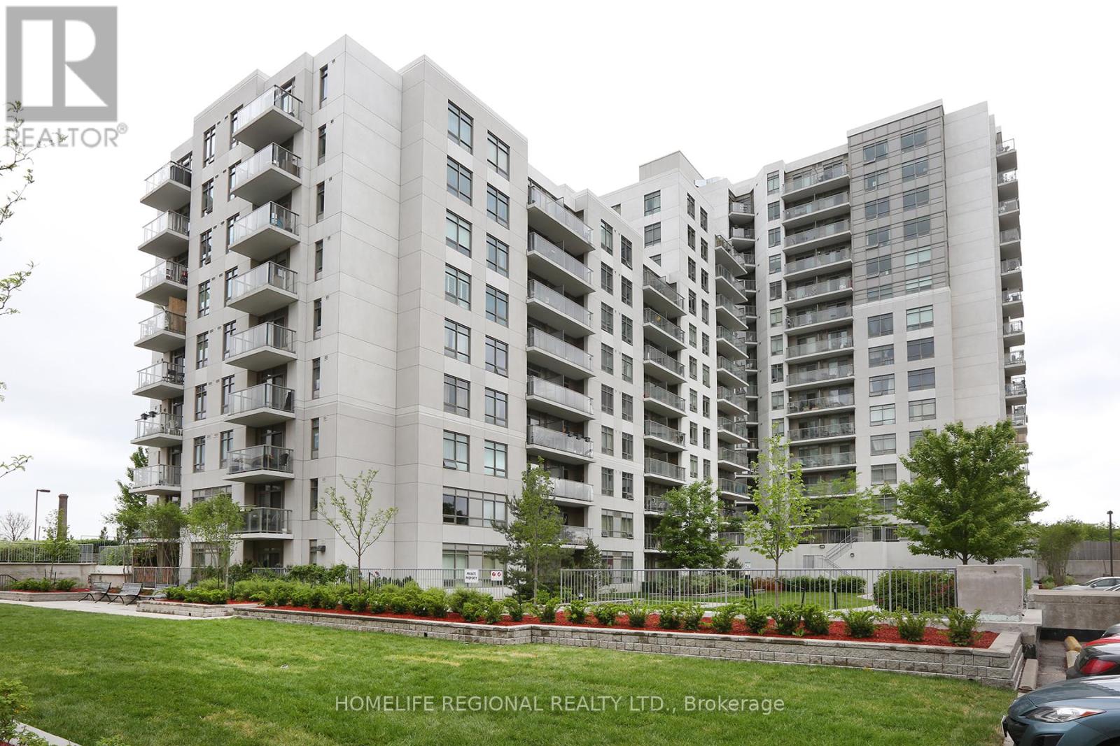 A large apartment building with a green lawn in front.