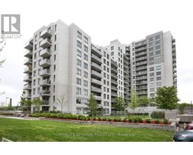 A large apartment building with a green lawn in front.
