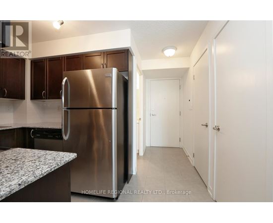 A kitchen with a stainless steel refrigerator and cabinets.