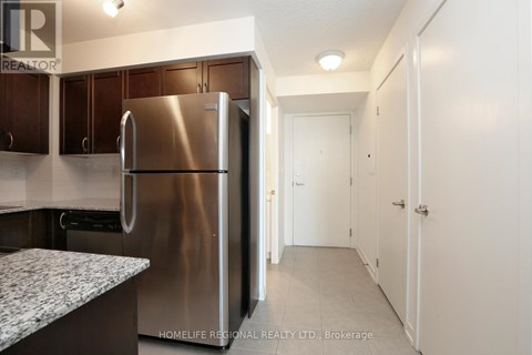 A kitchen with a stainless steel refrigerator and cabinets.