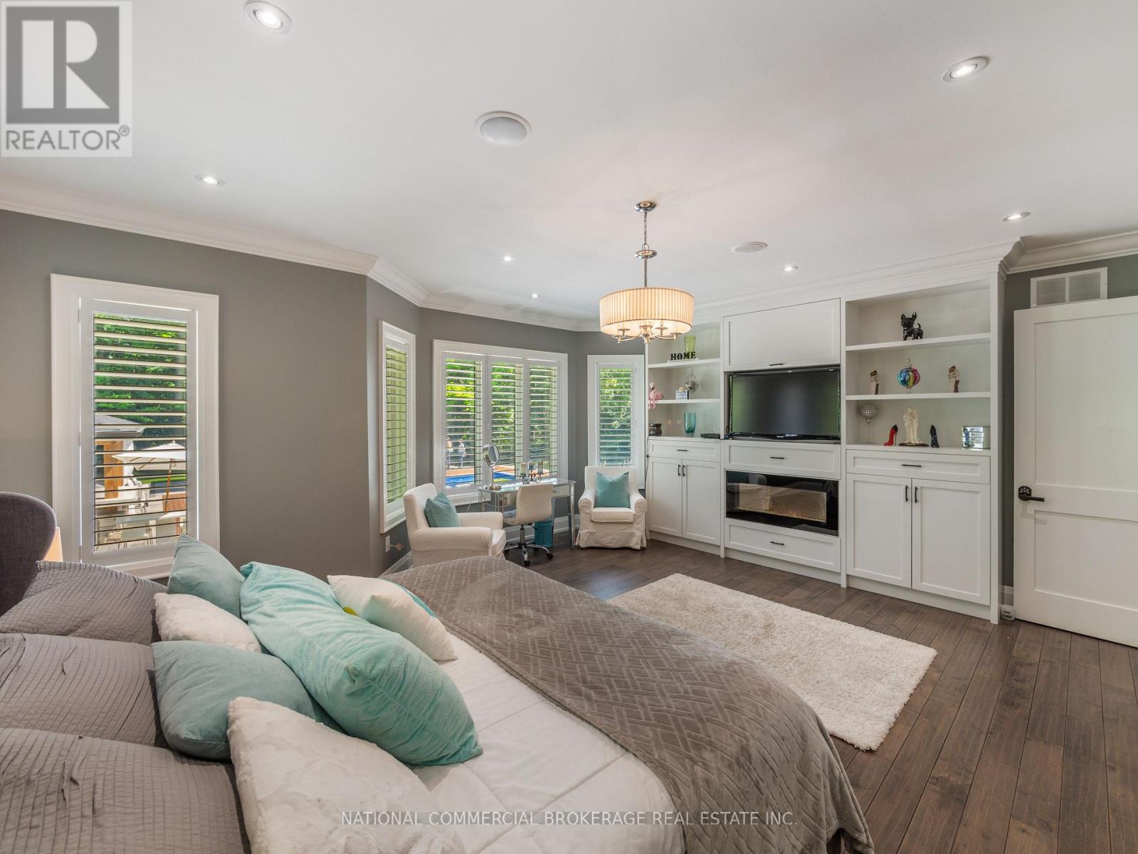 A bedroom with a bed, a chair, and a cabinet with a TV.
