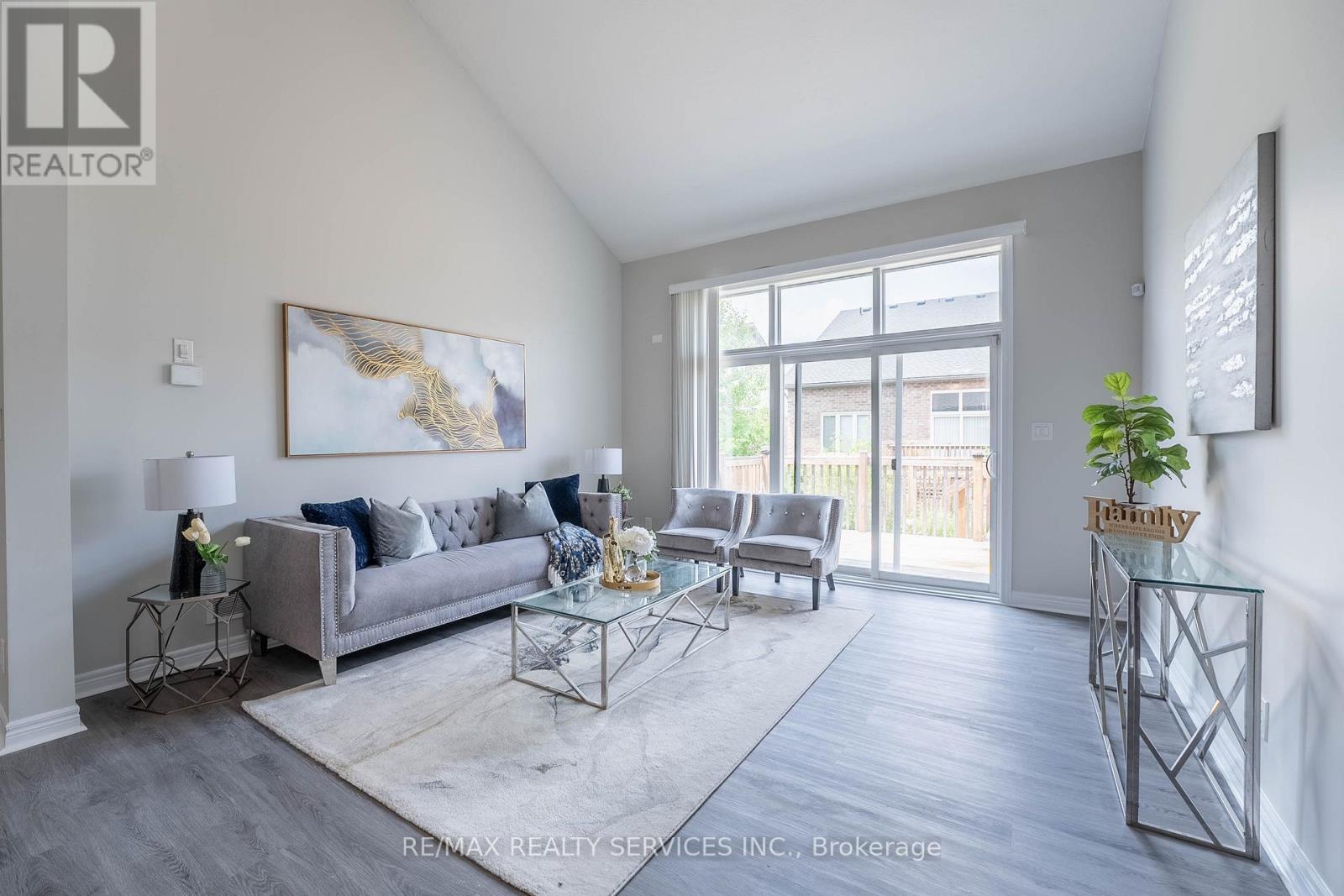 A living room with a grey couch and a glass table.