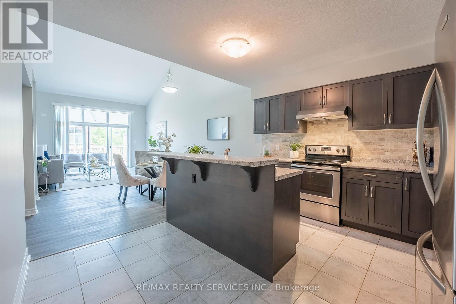 A kitchen with a black countertop and a refrigerator on the right side.