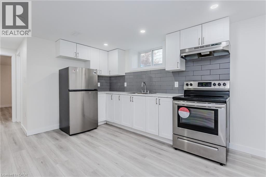 A modern kitchen with white cabinets and stainless steel appliances.