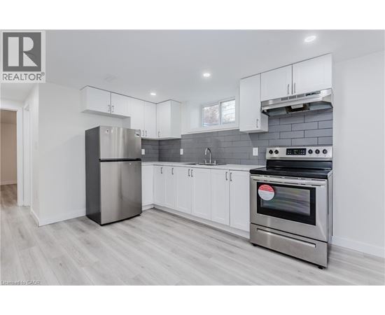 A modern kitchen with white cabinets and stainless steel appliances.