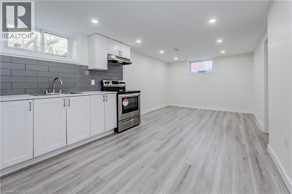 A kitchen with white cabinets and a grey floor.