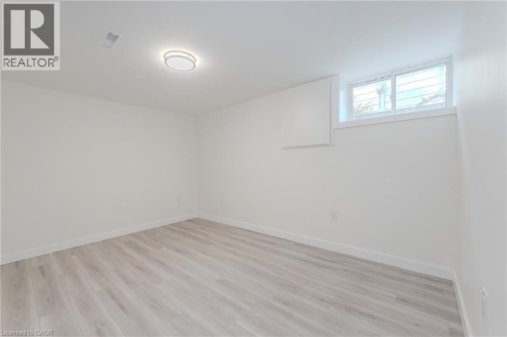 A spacious room with wooden flooring and a window.