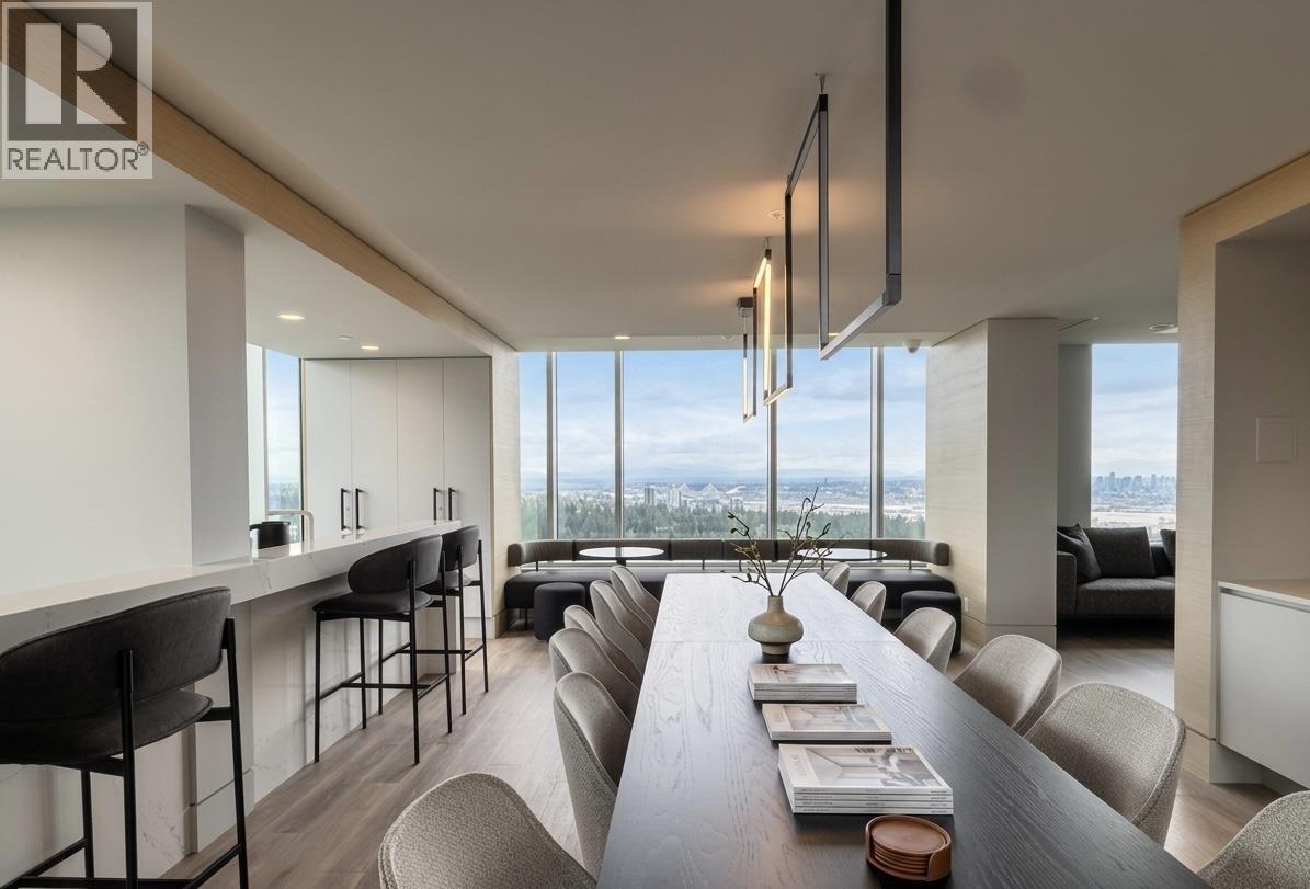 A modern dining room with a long table and chairs.