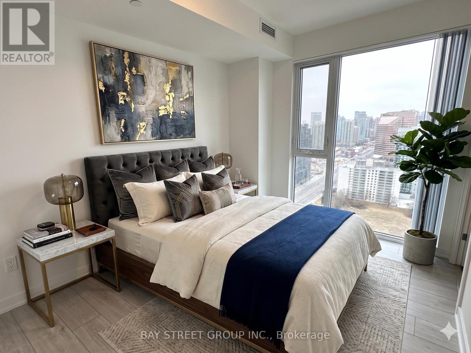 A bedroom with a large bed and a view of the city.