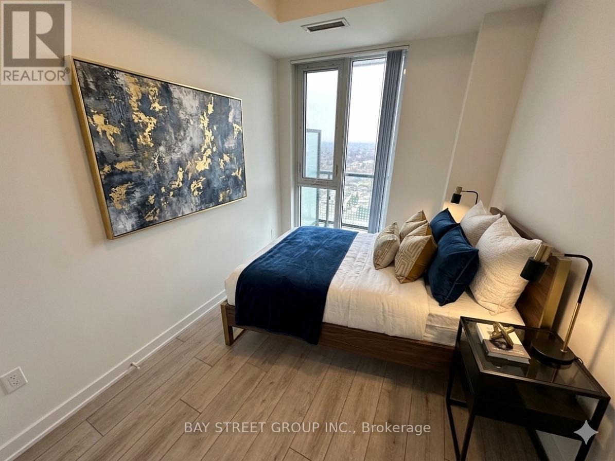A bedroom with a bed, nightstand, and a painting on the wall.