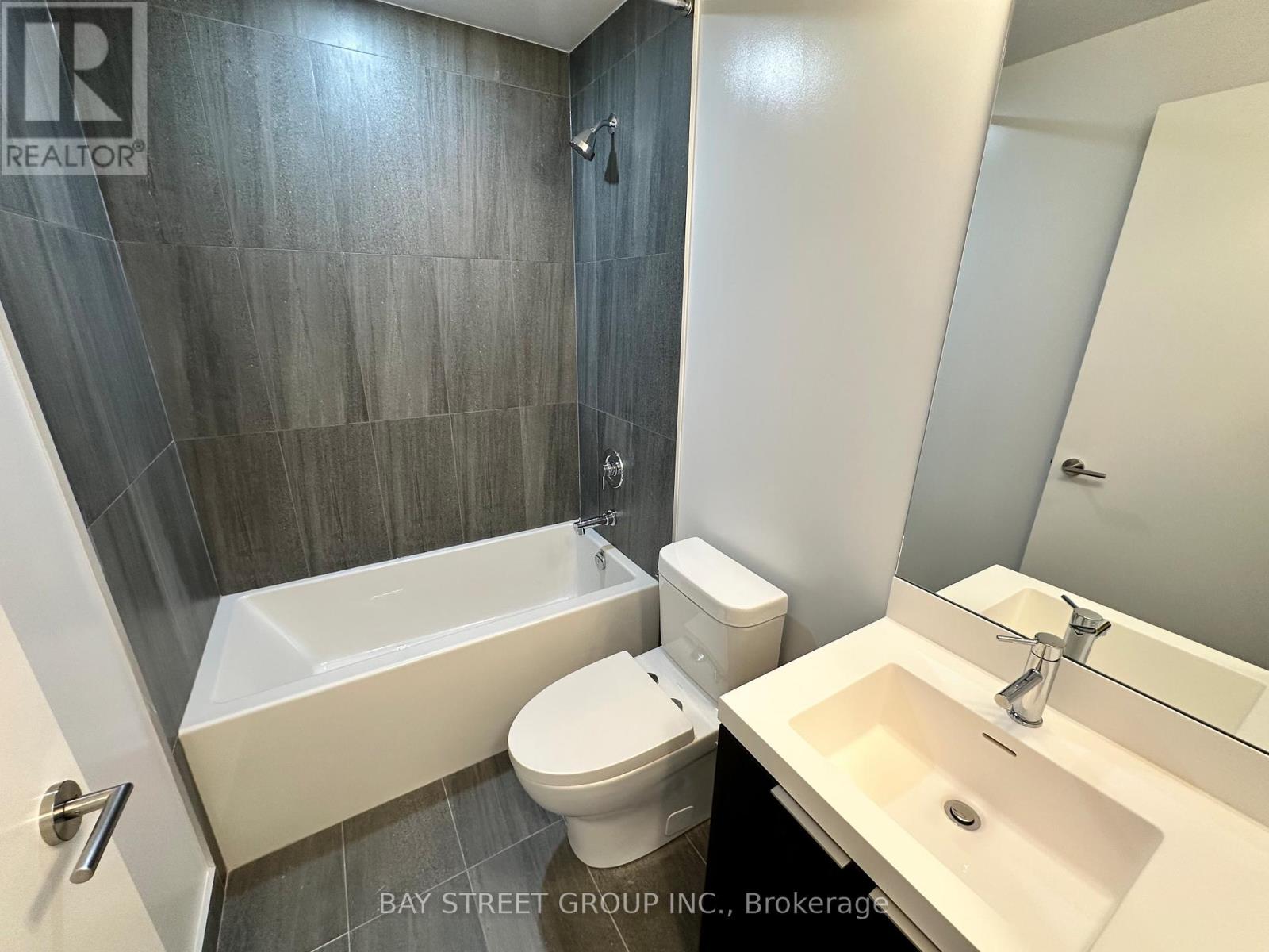 A bathroom with a toilet, sink, and bathtub.