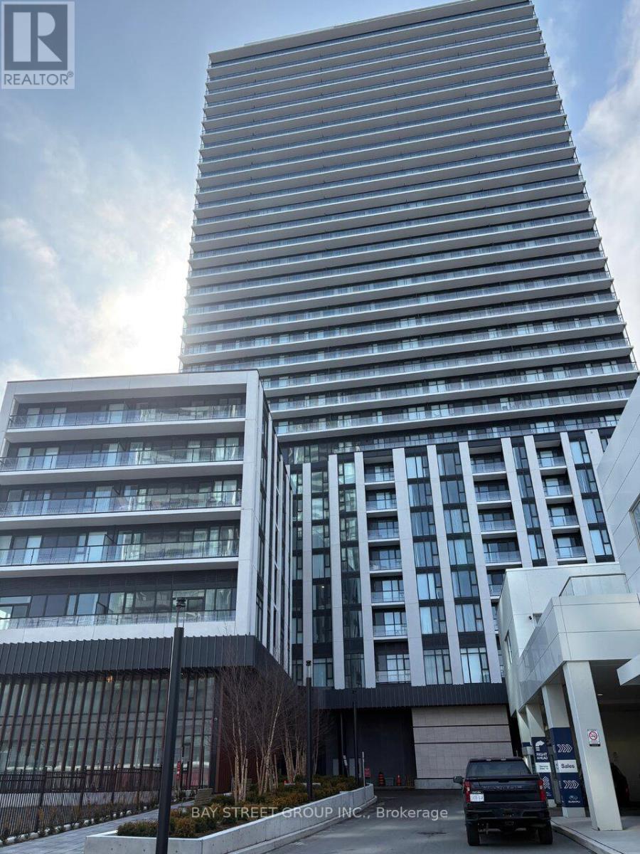 A tall building with a glass facade stands next to a shorter building with a black and white facade.
