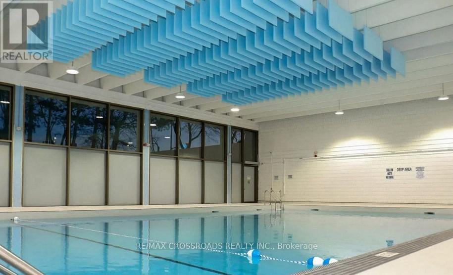 A swimming pool inside a building with a blue ceiling.