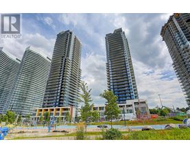 A view of a city with tall buildings and a playground in the foreground.