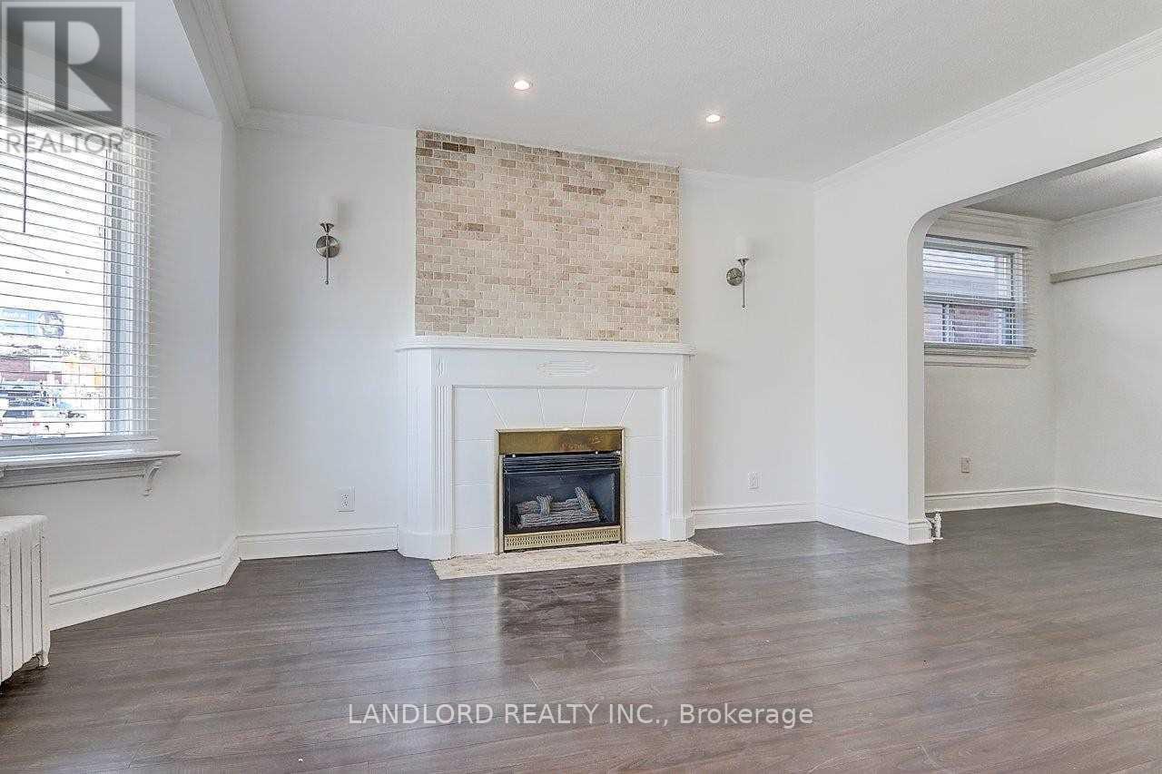 A living room with a fireplace and wood flooring.