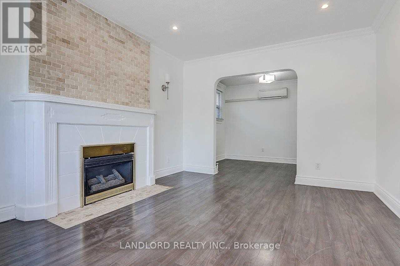 A room with a fireplace and wood flooring.