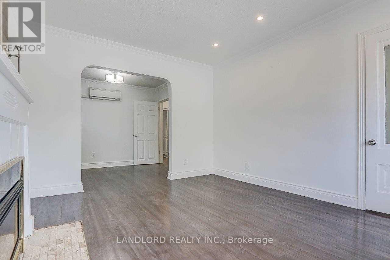 A spacious room with wood flooring and white walls, part of a property managed by Landlord Realty Inc.