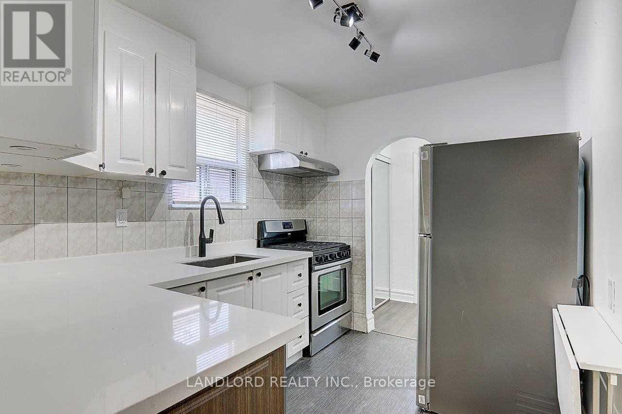 A kitchen with white cabinets and a marble countertop.