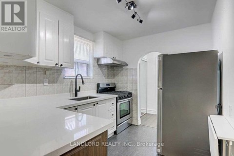 A kitchen with white cabinets and a marble countertop.