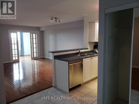 A kitchen with white cabinets and a stainless steel sink.