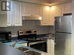 A kitchen with white cabinets and stainless steel appliances.