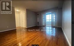 A room with wooden flooring and a window letting in light.