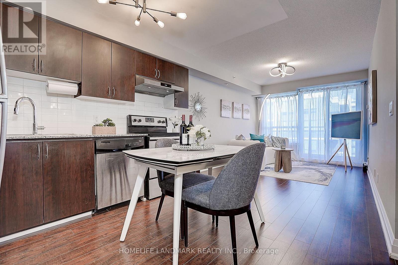 A kitchen with a table and chairs in front of it.
