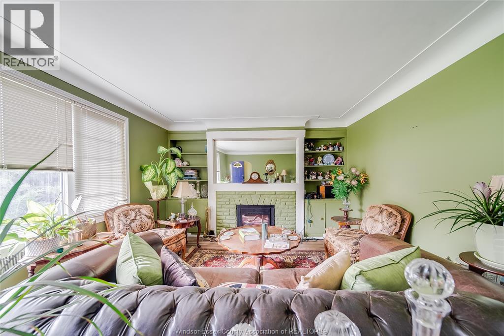 A living room with a grey sofa and a green wall.
