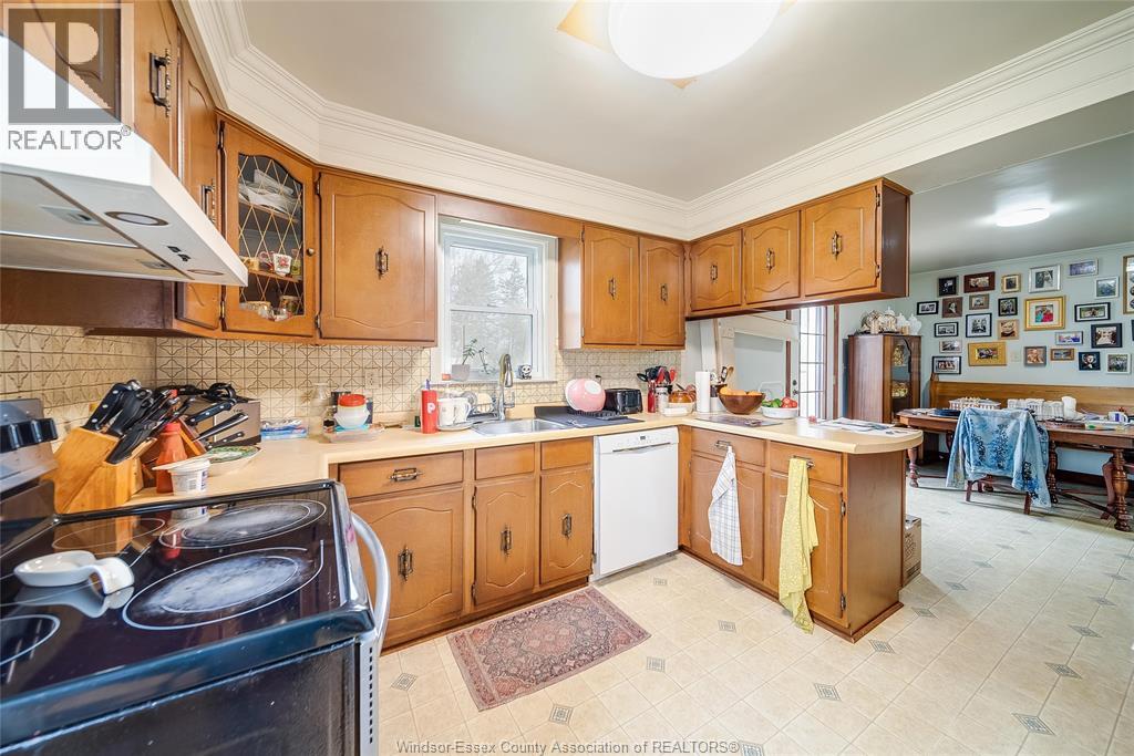 A kitchen with a black stove top oven and wooden cabinets.