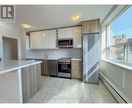 A kitchen with white cabinets and a refrigerator.