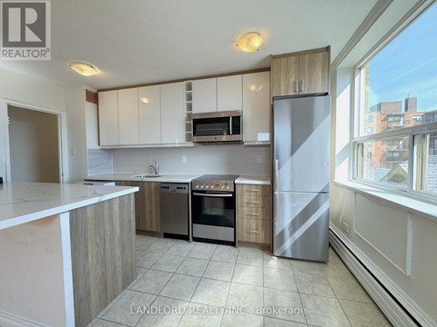 A kitchen with white cabinets and a refrigerator.